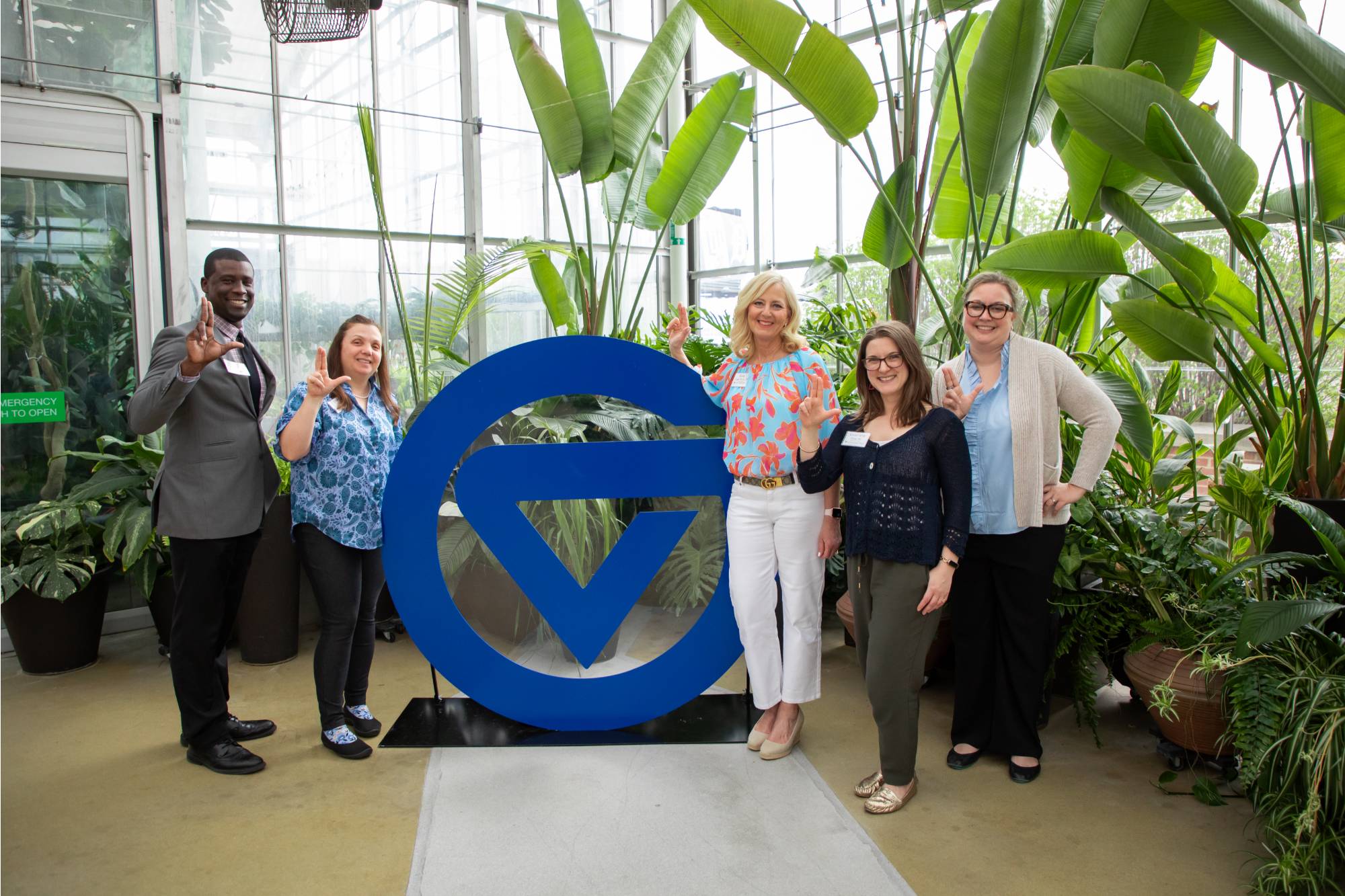 Group at event by circle G giving Anchor Up sign